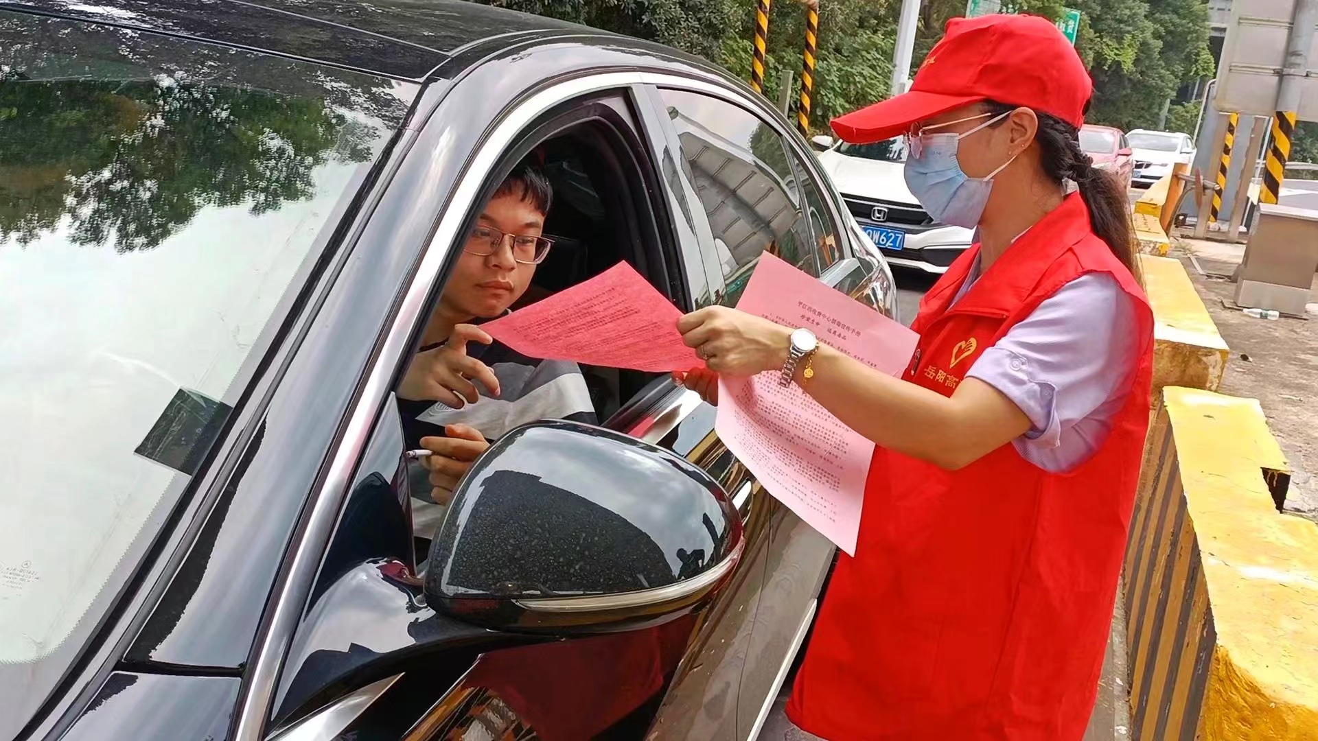 志愿者为司乘发放行车指南.jpg 志愿者为司乘发放行车指南.jpg
